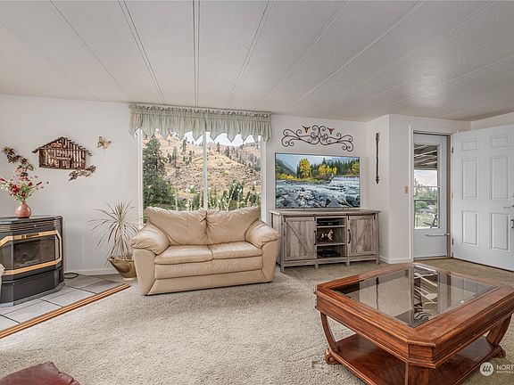 Bright and inviting living room with breathtaking mountain views and a cozy pellet stoveâ€”perfect for creating new memories in your future home.>