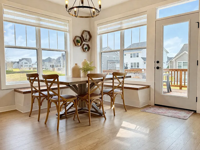 Sun-filled dining nook with custom built-in bench seating and expansive windows overlooking the backyard. Seamless access to the deck creates an ideal space for everyday dining and entertaining.