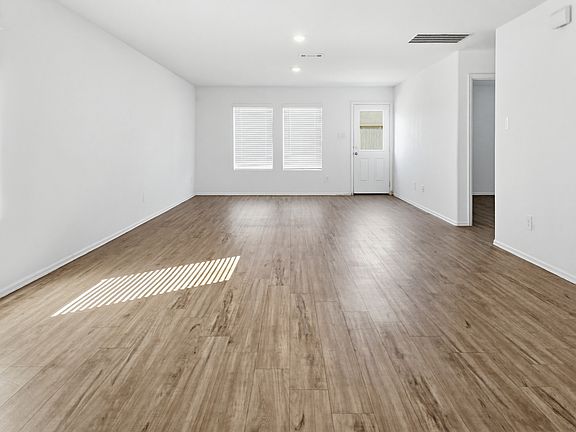Expansive open-concept living area featuring beautiful vinyl plank flooring and recessed lighting. The perfect blank canvas for your furniture and decor!