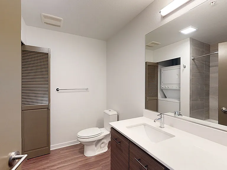 Apartment bathroom with wood-style flooring.
