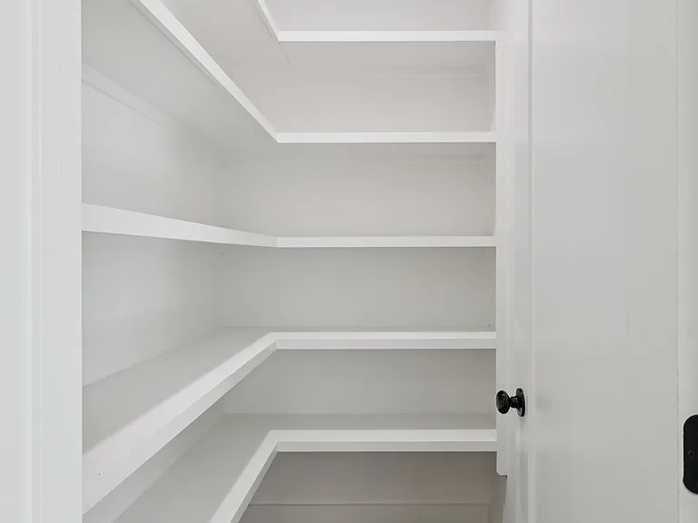 Walk-in pantry with built-in shelving and generous storage space.