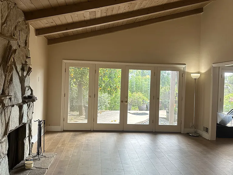 Living room with fireplace and high ceiling.
