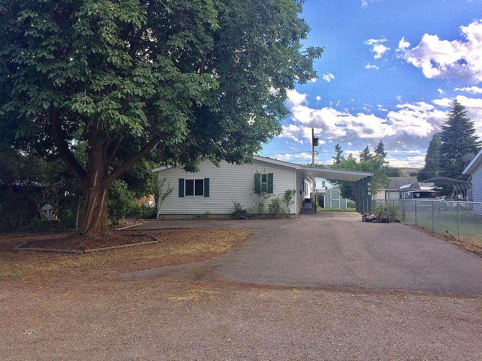 Spacious home with carport and paved parking area.
