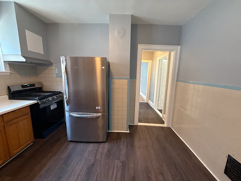 Kitchen with refrigerator, gas oven stove and range hood