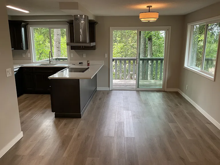 Open floor plan, dining room with slider to 16' deck surrounded by trees