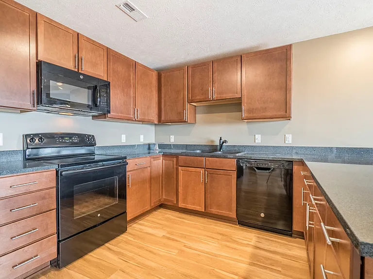 Our Caramel design style features lighter, warm cabinetry with dark granite countertops.