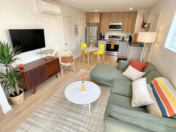 Entry flows into living room and adjoining kitchen with stairs to the left. Patio door is back on the right and downstairs half bath on the left.