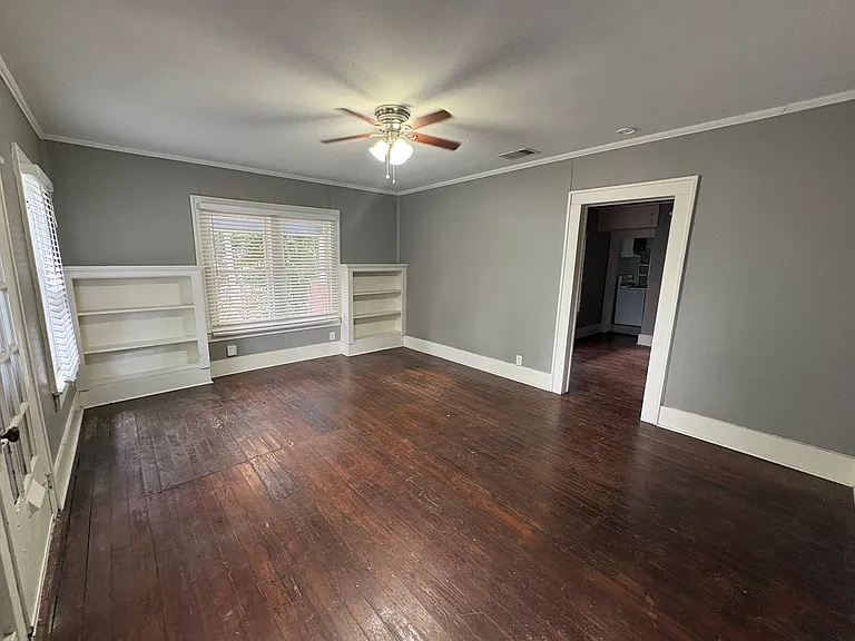Spacious living room with original hardwood floors.