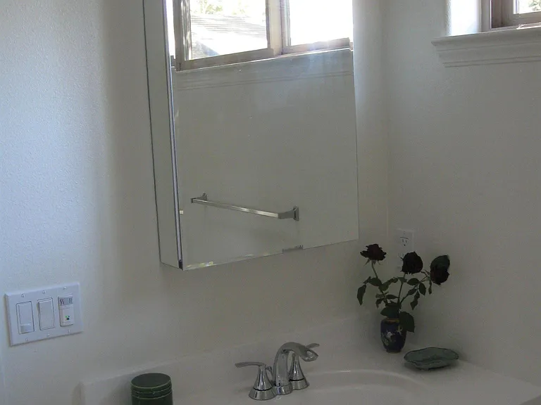 Hickory cabinet with sink, toilet and neo-angle shower in bathroom