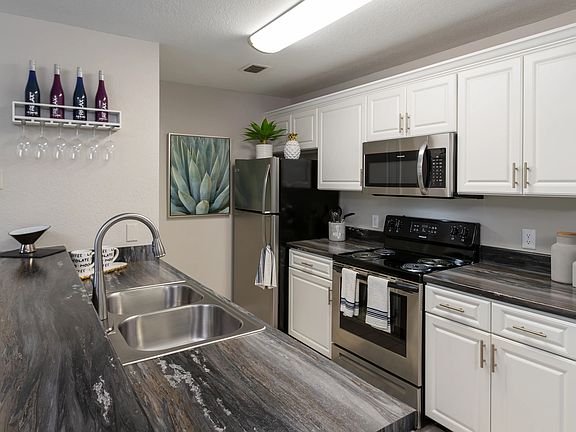 Experience a contemporary kitchen at Soleil Blu Apartments in St Cloud, FL, featuring stainless steel appliances, sleek countertops, custom cabinetry, and stylish finishes.