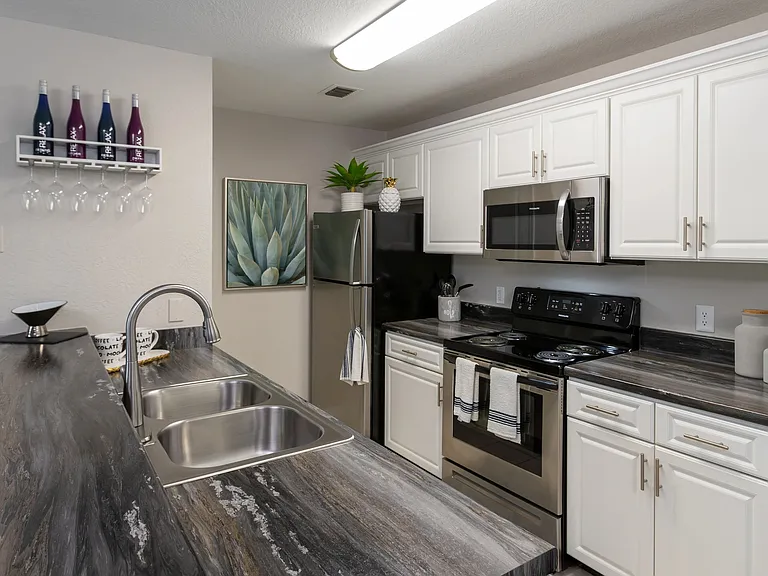 Experience a contemporary kitchen at Soleil Blu Apartments in St Cloud, FL, featuring stainless steel appliances, sleek countertops, custom cabinetry, and stylish finishes.