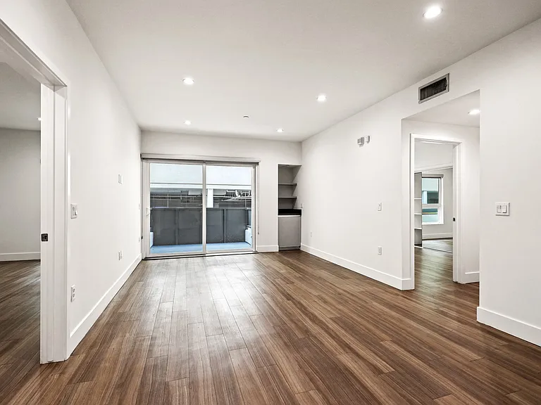 Living Room with Built-In Storage, Patio, and Vinyl Flooring