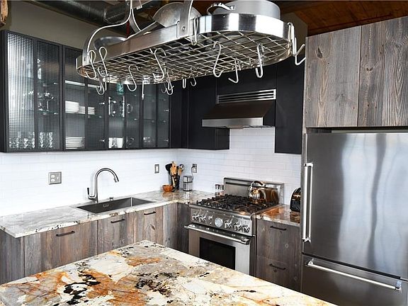 Gutted to the studs-  This gorgeous kitchen was featured in the Jan 2017 issue of Atlanta Magazine for it's unique distress cabinetry, gorgeous waterfall quartz countertops and high-end appliances.  It offers a tremendous amount of storage in a compact space and has views of the skyline and living areas.