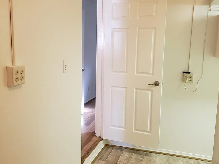 This photo shows looking towards the hall way entrance from the attached garage/laundry area Notice the new tile floor. This is fabulous area that is finished, high ceiling, ceiling fan and insulated garage door the keep cool and cozy