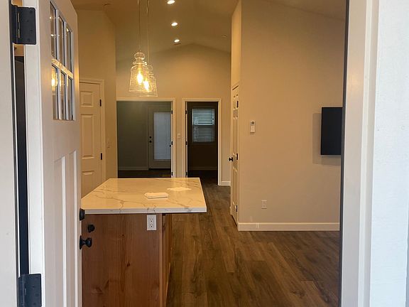 View through front door. Open floor plan. Vaulted ceiling. Spacious interior.