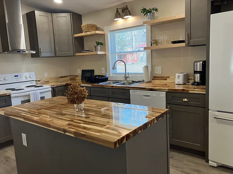 New Kitchen with dishwasher, electric stove, island storage, and open shelving