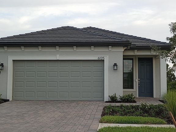 Double car garage with epoxy floor and wall cabinets.
