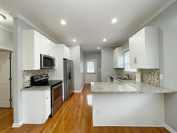 Kitchen with stainless steel appliances: electric stove, refrigerator, dishwasher