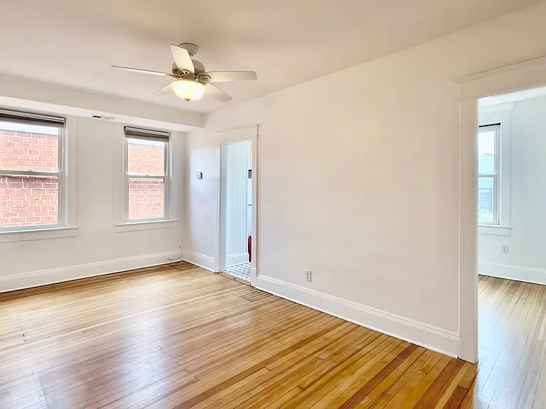 living room facing kitchen and second bedroom/office space