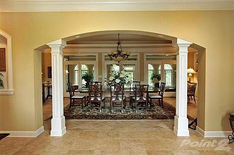 As you enter the home the dining room is ahead separated by columns from the entry.  French doors across the back of the dining room open onto the sun room.  Tile flooring throughout.  The kitchen lies to the left of the entry while the owner's suite and library are to your right.