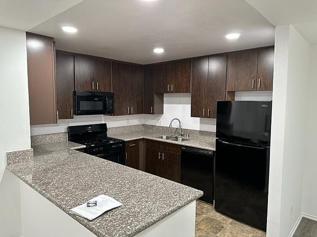 Modern kitchen with oven, microwave, refrigerator, dishwasher, and garbage disposal.