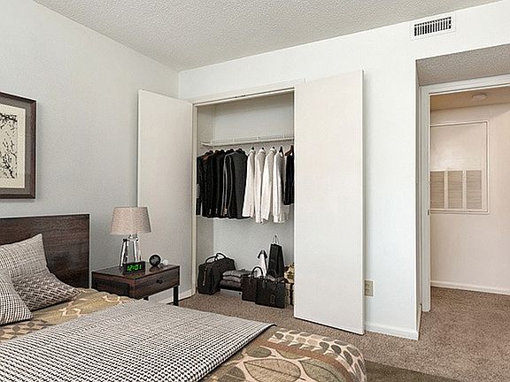 Step into this chic bedroom, where style meets functionality with a spacious closet and cozy decor.