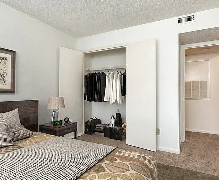 Step into this chic bedroom, where style meets functionality with a spacious closet and cozy decor.