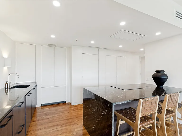 The kitchen features a sleek, minimalist aesthetic.