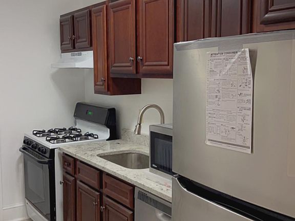 Newly renovated Kitchen with new stove with fan hood, dishwasher, microwave, and refrigerator
