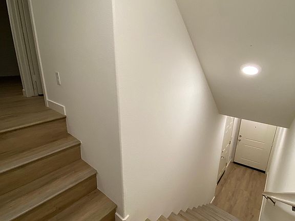 Stairs from entry level to main level with living, dining, kitchen, half bath and balcony.