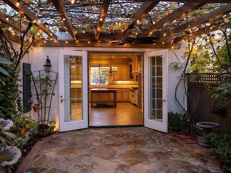 Private patio with pergola, ambient lighting, and seamless indoor outdoor flow from kitchen