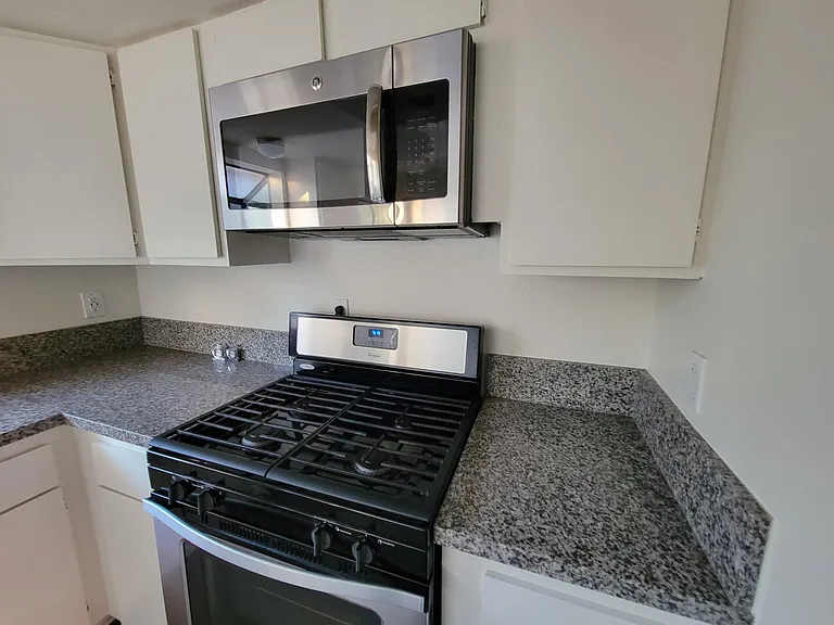 Kitchen: Granite Countertop, Stove, Microwave & lots of Cabinets