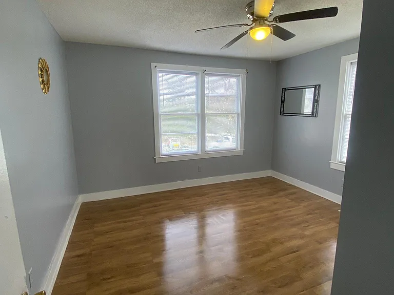 Large master bedroom hardwood flooring, and ceiling fan