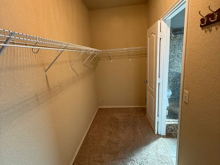 Spacious carpeted walk in closet in the downstairs bedroom with lots of room and privacy