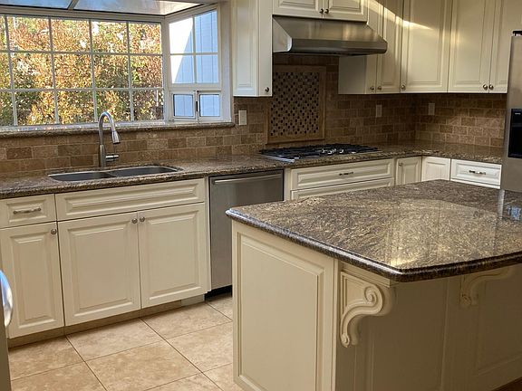 Chef kitchen with microwave/convection oven, a second full size GE Profile oven with separate 5 burner gas range and stainless refrigerator