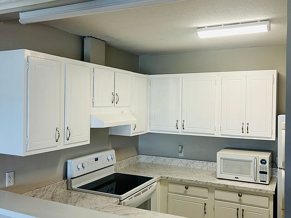 Kitchen with new counter tops and newly painted cabinets!