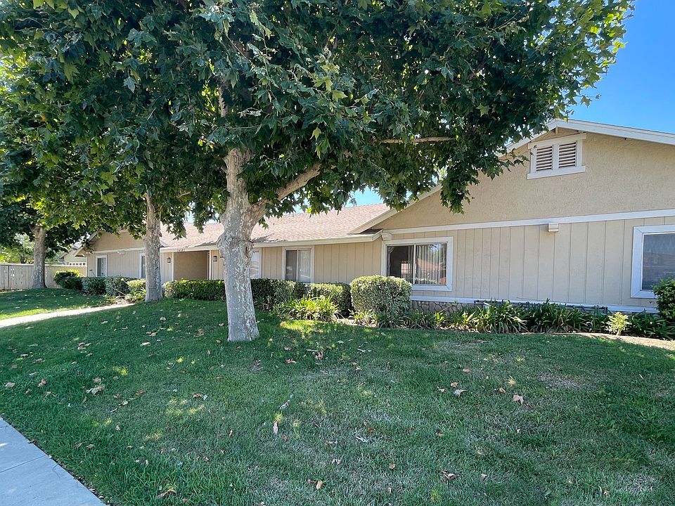 Front landscaping with marture Eucalyptus trees and well established grass at Eucalyptus Apartments in Moreno Valley, California.