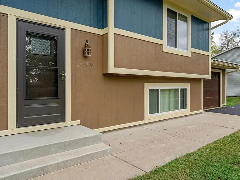 Front of unit showing recent exterior updates and attached single stall garage with an additional three parking spaces in the large paved driveway