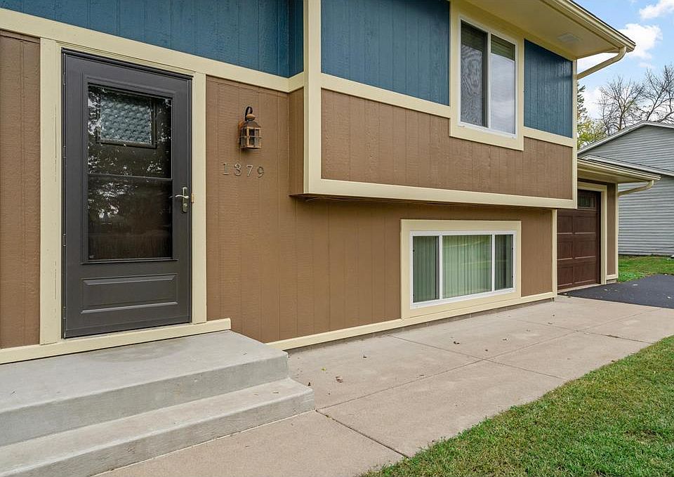 Front of unit showing recent exterior updates and attached single stall garage with an additional three parking spaces in the large paved driveway