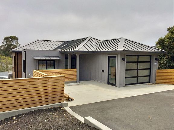 FRONT ELEVATION OF 31 N KNOLL. PRIVATE DRIVEWAY, 1 CAR GARAGE, AND INDIVIDUAL PARKING AREA WITH 3 ADDITIONAL UNCOVERED SPACES.