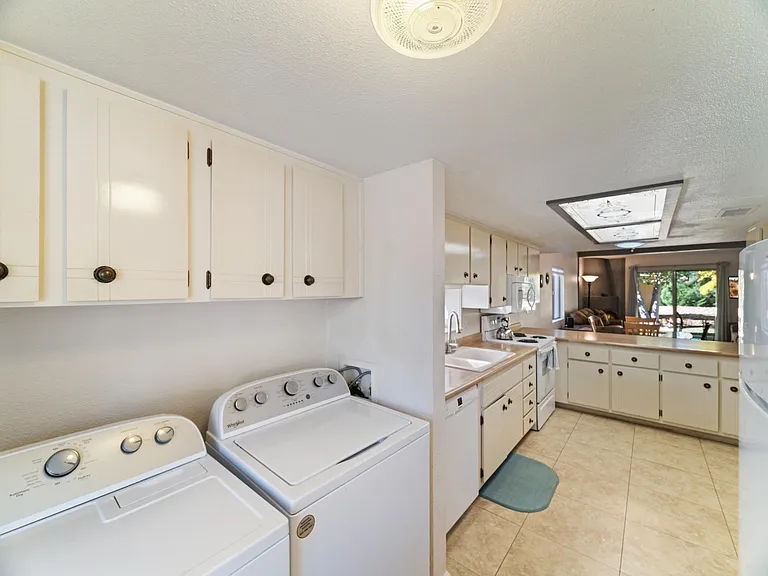Brand new washer and dryer in laundry room next to kitchen