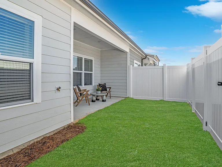 Covered back patio with fenced in yard.