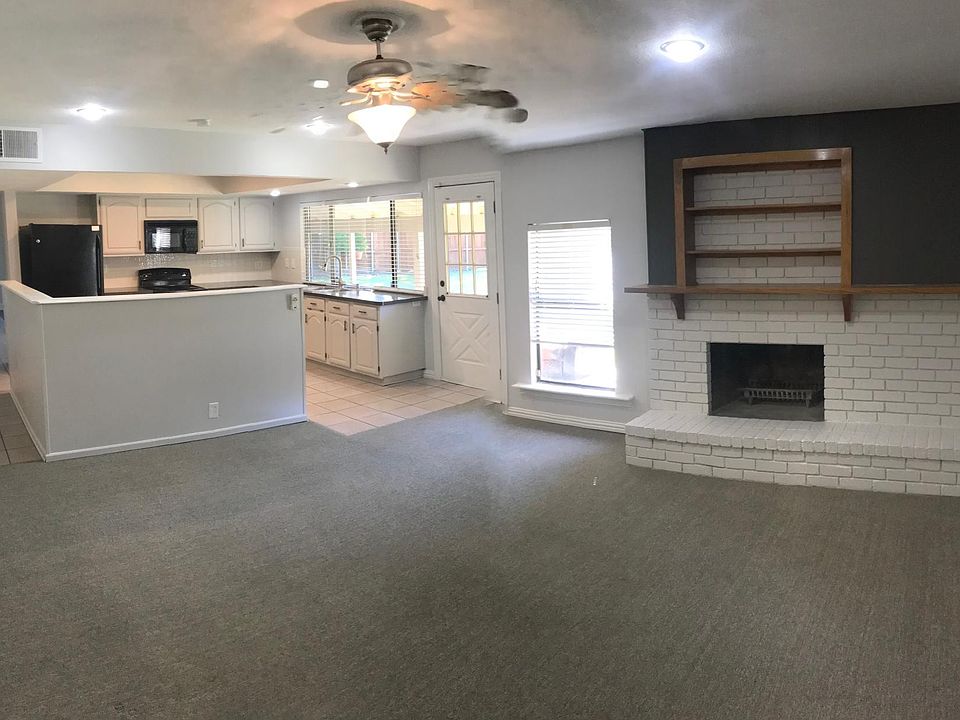 Kitchen and adjacent living area near back of home. Kitchen window looks out into backyard and covered patio. The floors in kitchen and this living area have been updated since this phot was taken.
