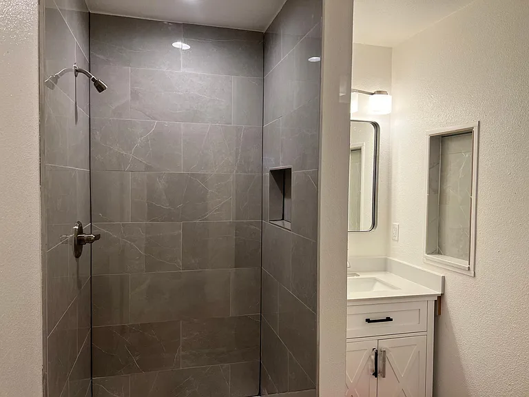 beautiful tile shower and granite vanity
