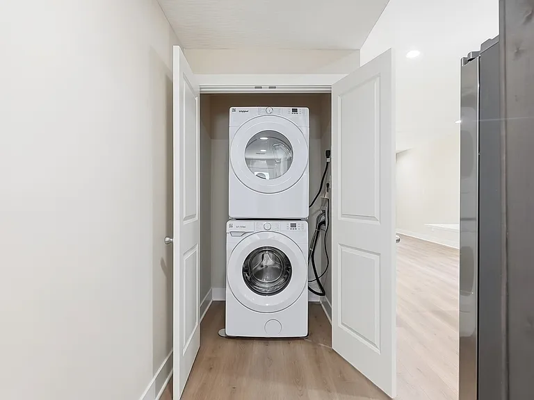 Stacked washer and dryer in utility closet with room for storage