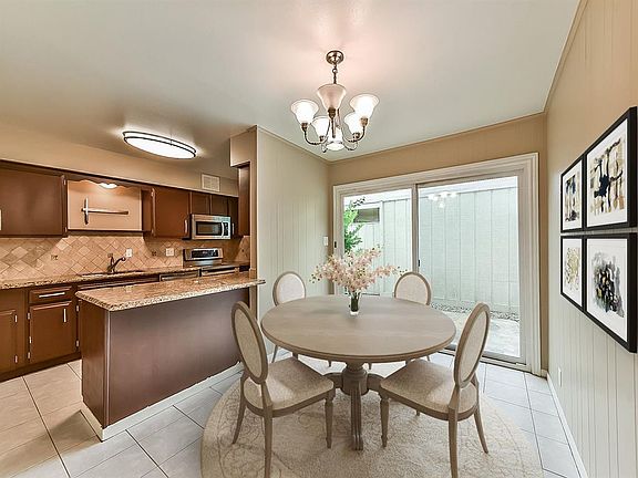 Updated kitchen, with granite and stainless appliances, opens into a sunny dining room and private courtyard. (photo has been virtually staged)