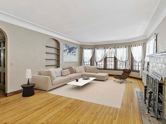 Living room with woodburning fireplace and view to the creek and park. Living room has been virtually staged.