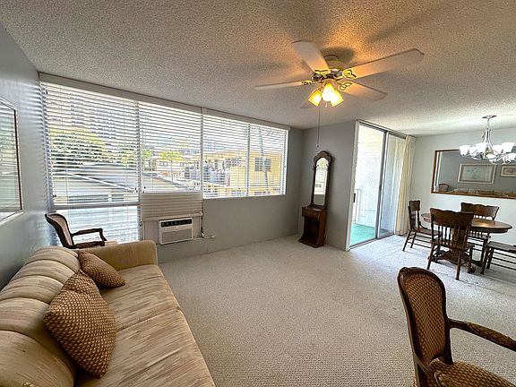 Living room with ceiling fan and air conditioner