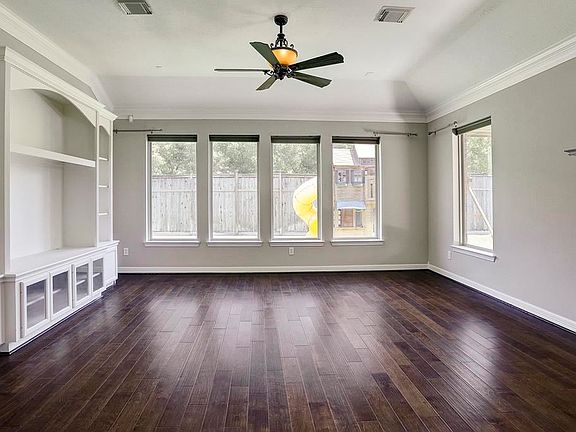 Huge family room features amazing built-in media entertainment center and a lot of natural lighting from the many windows.