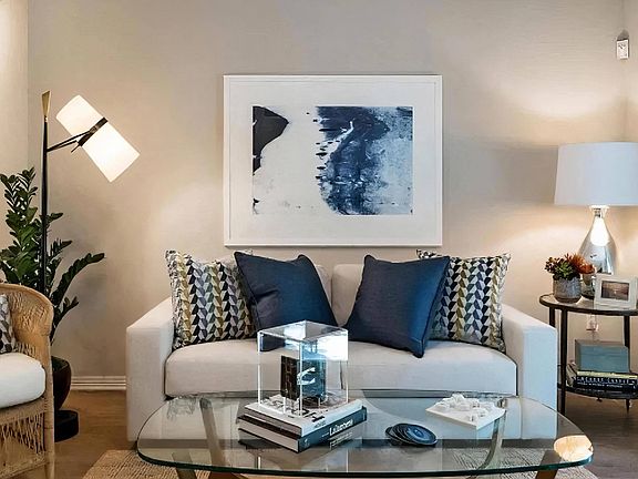 Well-Appointed Living Room with Glass Coffee Table and Soft Lighting